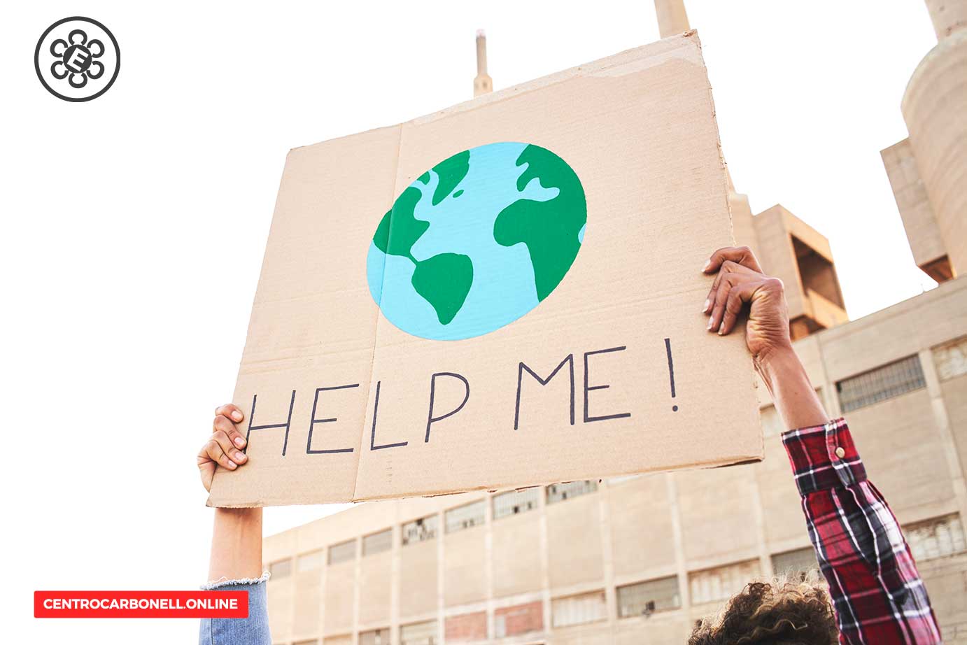 Una persona sostiene un cartel que dice 'HELP ME!' con una ilustración del planeta Tierra, en un ambiente urbano industrial.
