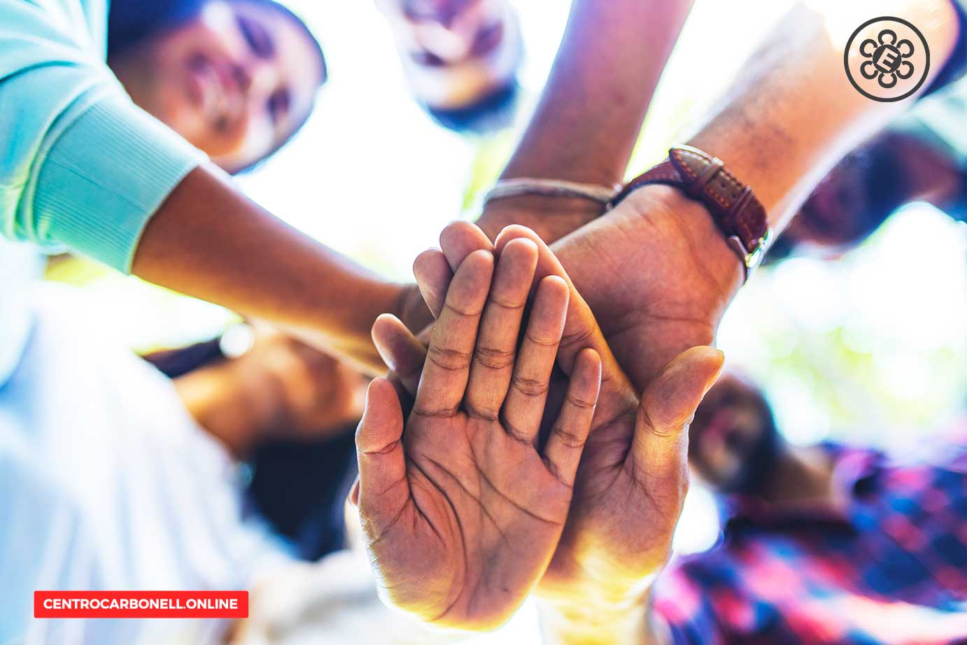 Grupo de personas uniendo sus manos en señal de colaboración y apoyo.