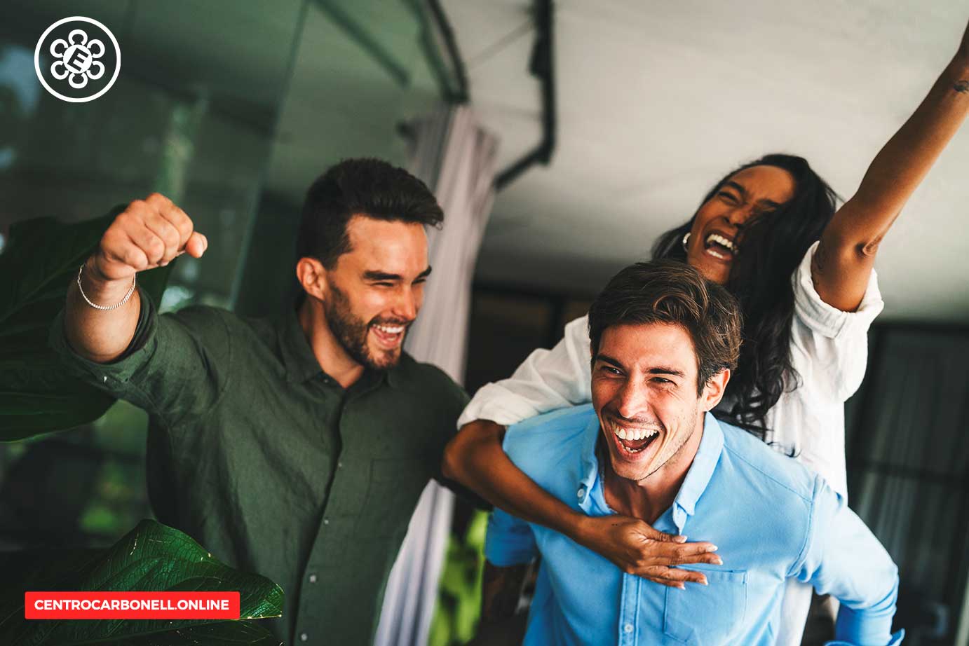 Grupo de tres personas sonrientes y felices, disfrutando de un momento juntos en un ambiente luminoso y moderno.