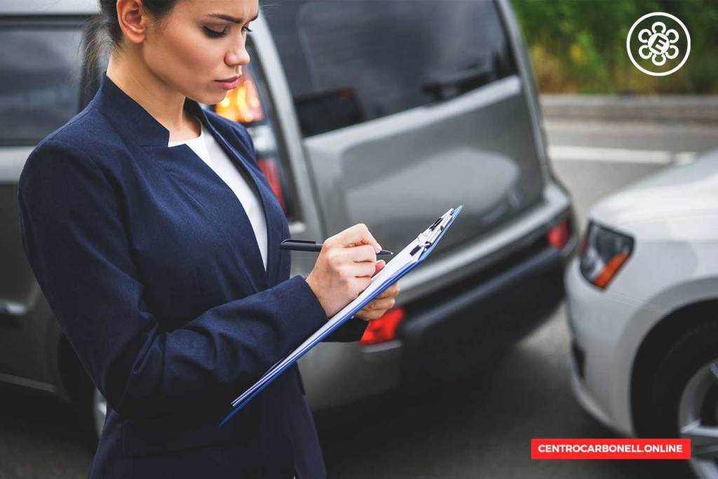 Mujer en traje oscuro tomando notas en una libreta mientras observa dos coches en un accidente de tráfico.