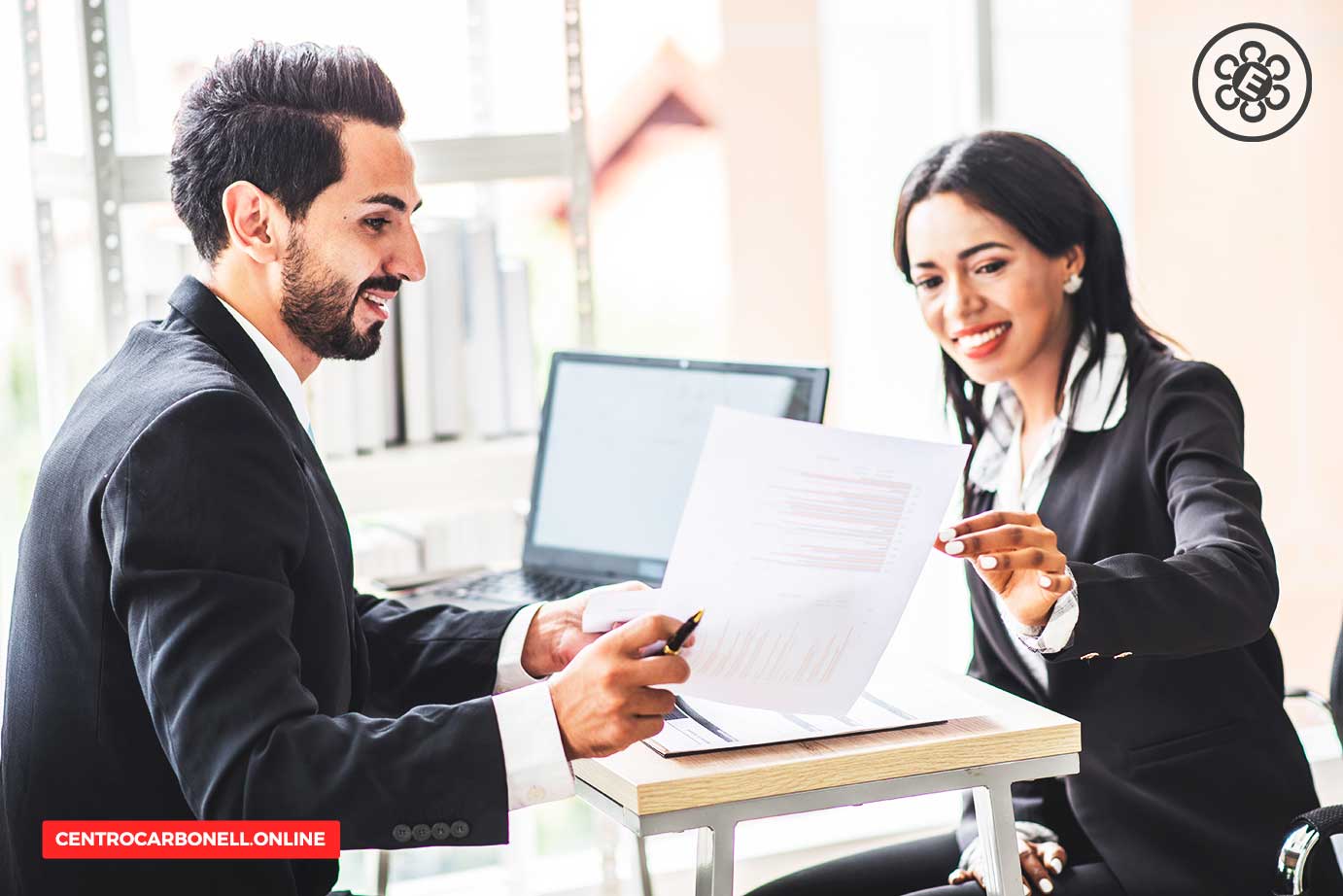 Dos profesionales discutiendo un documento contractual en un entorno de oficina moderna.
