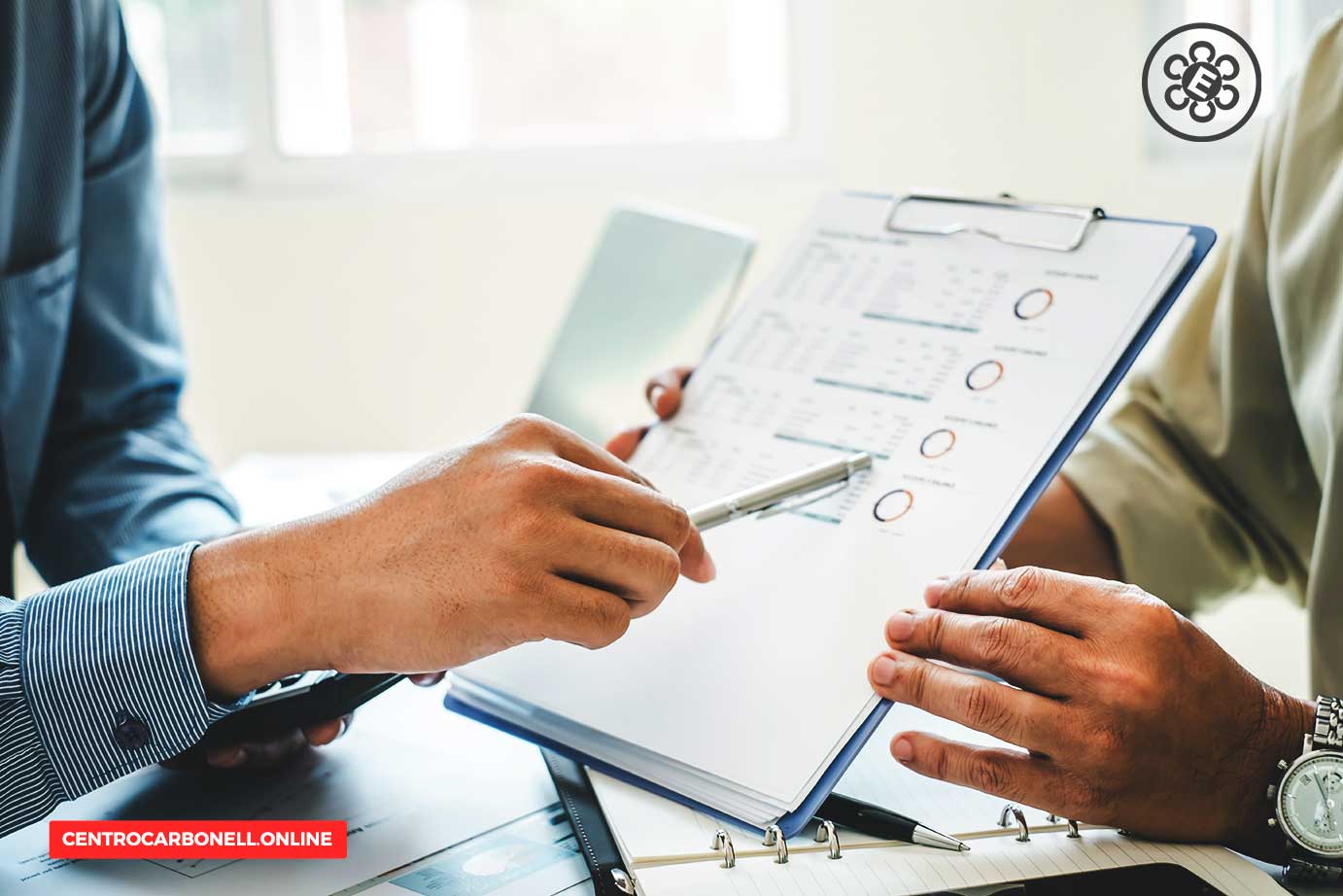 Dos personas discutiendo sobre informes y gráficos de compliance empresarial, sosteniendo un bolígrafo y un portafolios con documentos.
