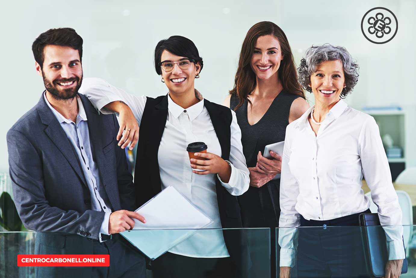 Grupo diverso de profesionales sonriendo mientras están de pie en una oficina moderna, con un ambiente amigable y colaborativo.