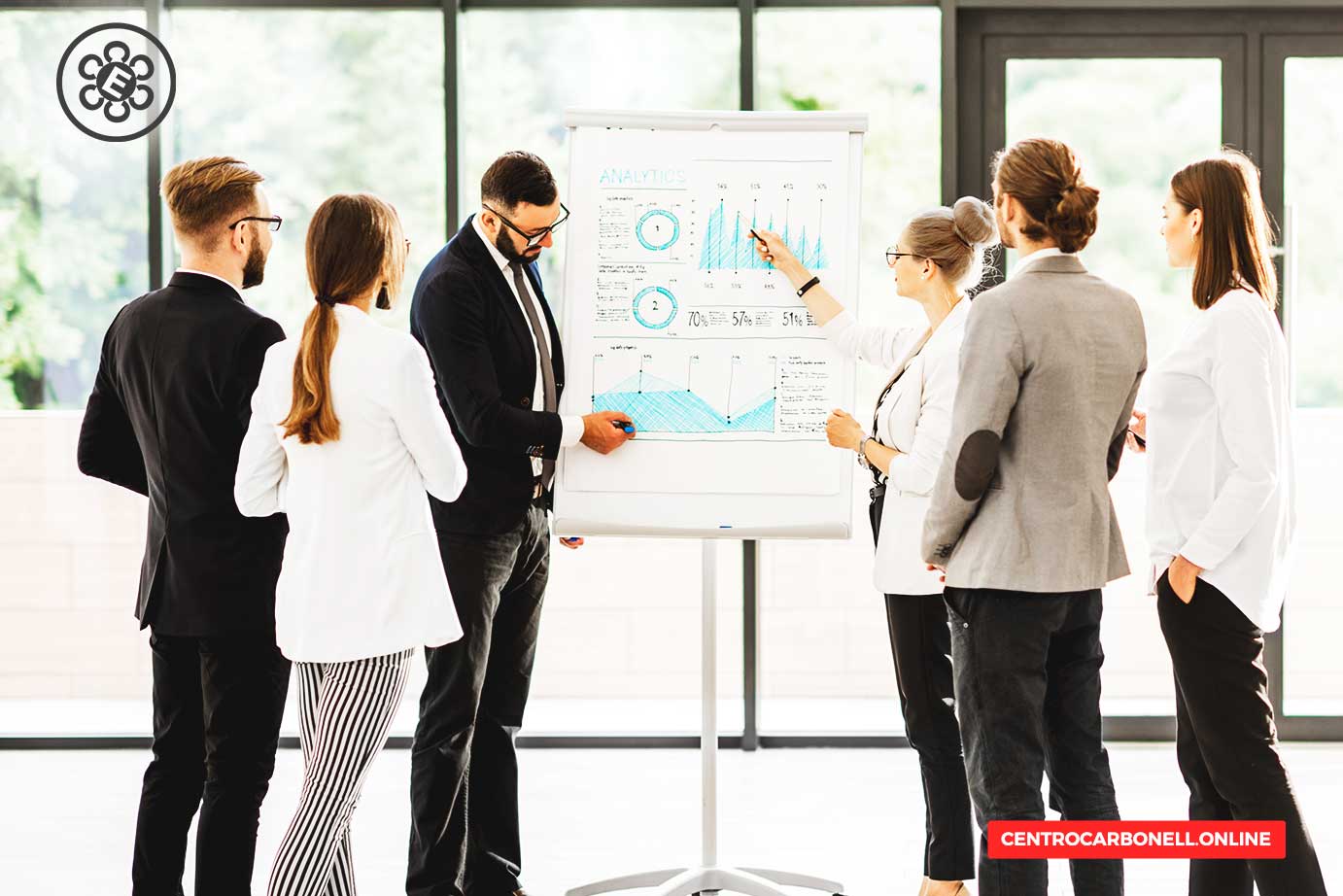 Grupo de profesionales discutiendo gráficos y datos en una presentación de cumplimiento empresarial.