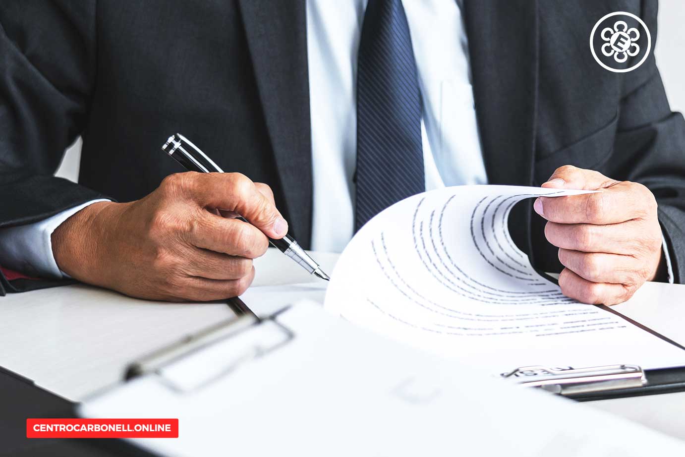Hombre de negocios revisando y firmando documentos en un escritorio.