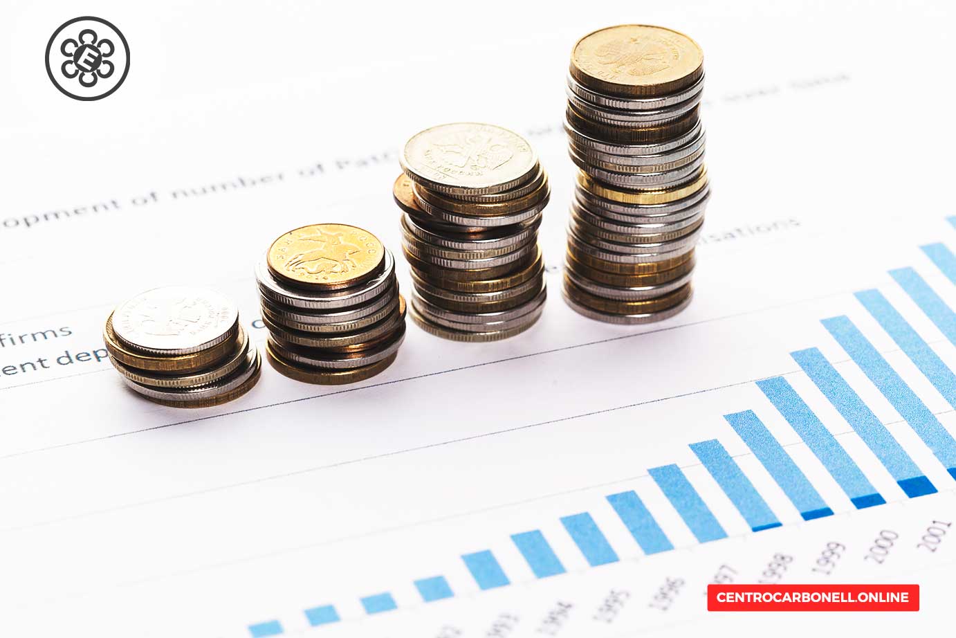 Monedas apiladas en diferentes alturas sobre un fondo de gráficos financieros.