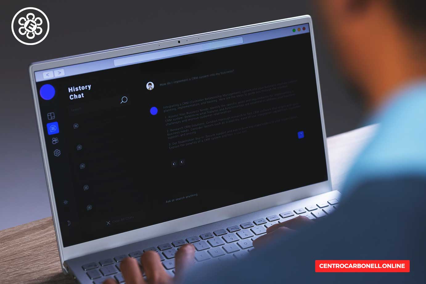 Una persona usando una computadora portátil con una interfaz de chat oscura y opciones de historial visible en la pantalla.