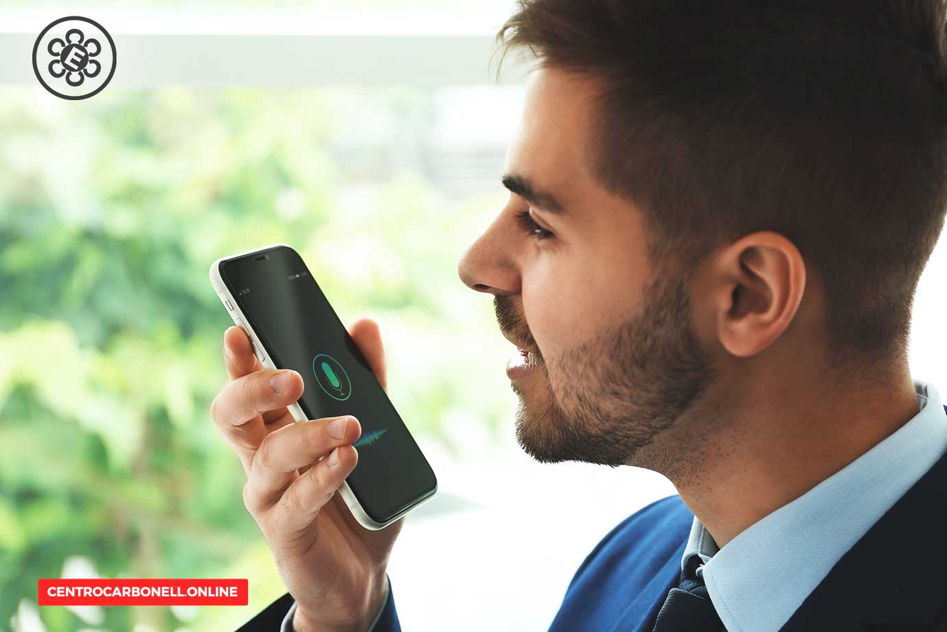 Hombre hablando por teléfono inteligente, usando la función de voz, con fondo de naturaleza difusa.