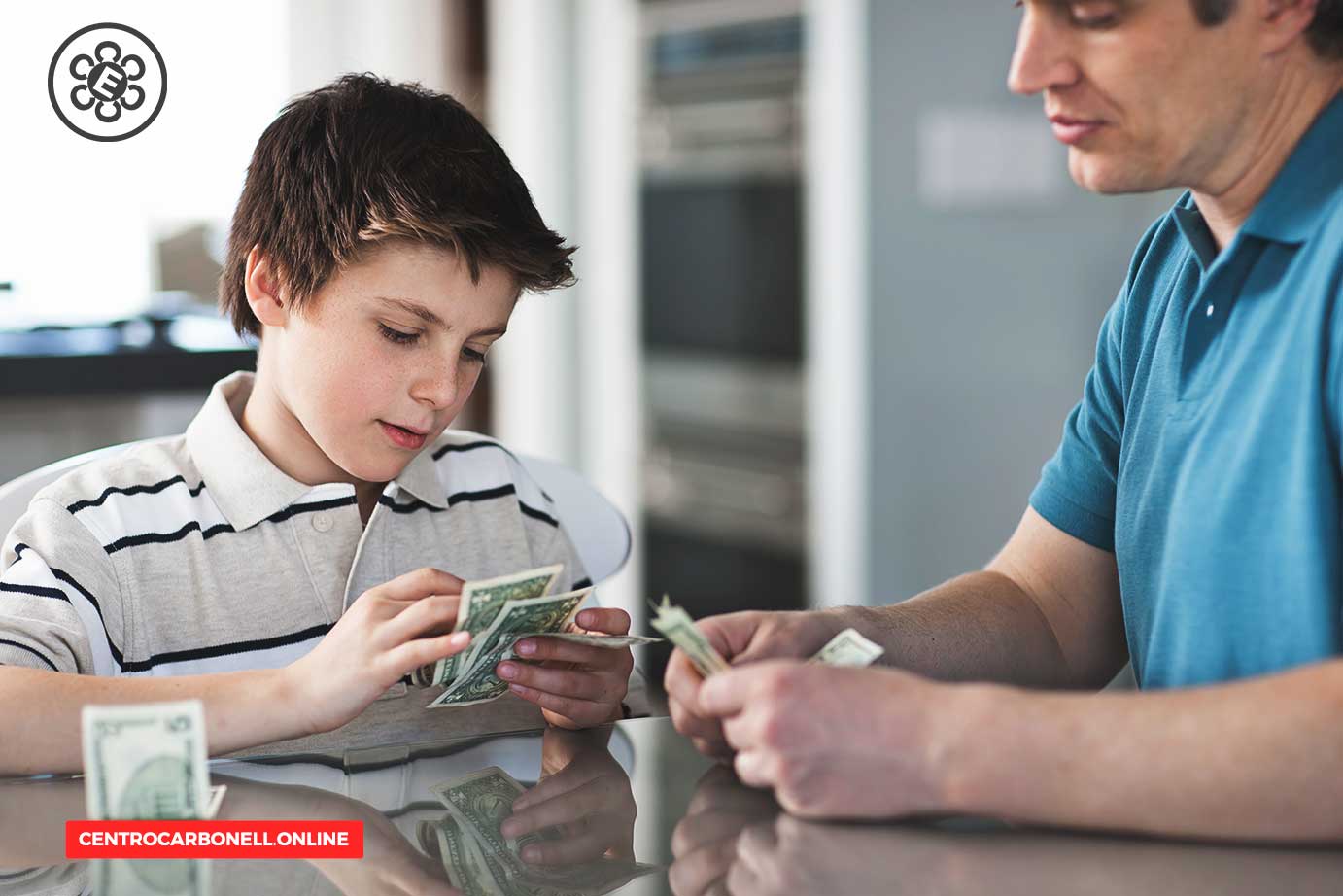 Un niño y un adulto sentados a una mesa, contando billetes de dinero.