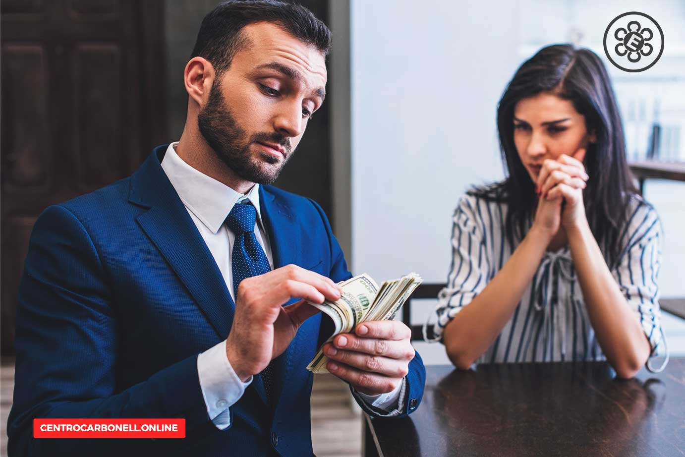 Hombre en traje revisando billetes mientras una mujer lo observa con expresión preocupada, en un ambiente de oficina.